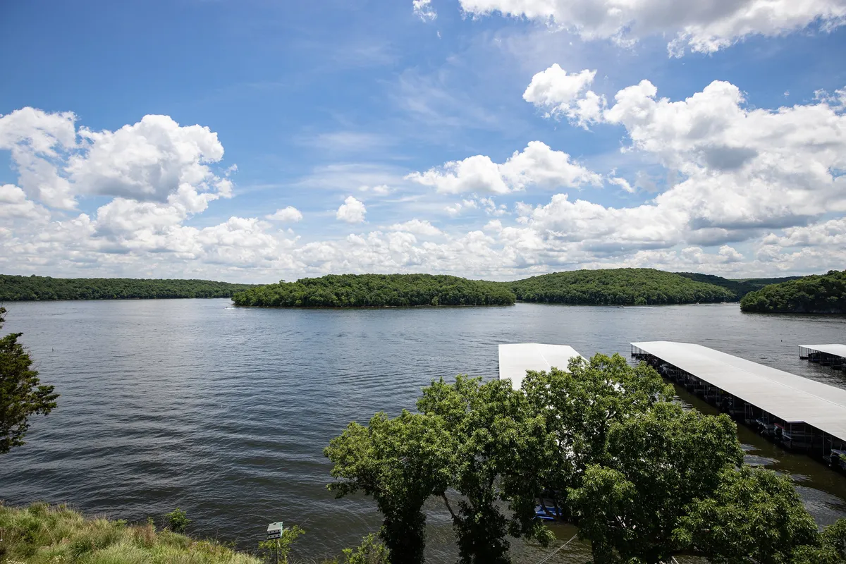 A tranquil lake view with distant islands, marina docks, and a broad sky above. The image evokes peace, spaciousness, and the allure of lakeside exploration and wildlife spotting.