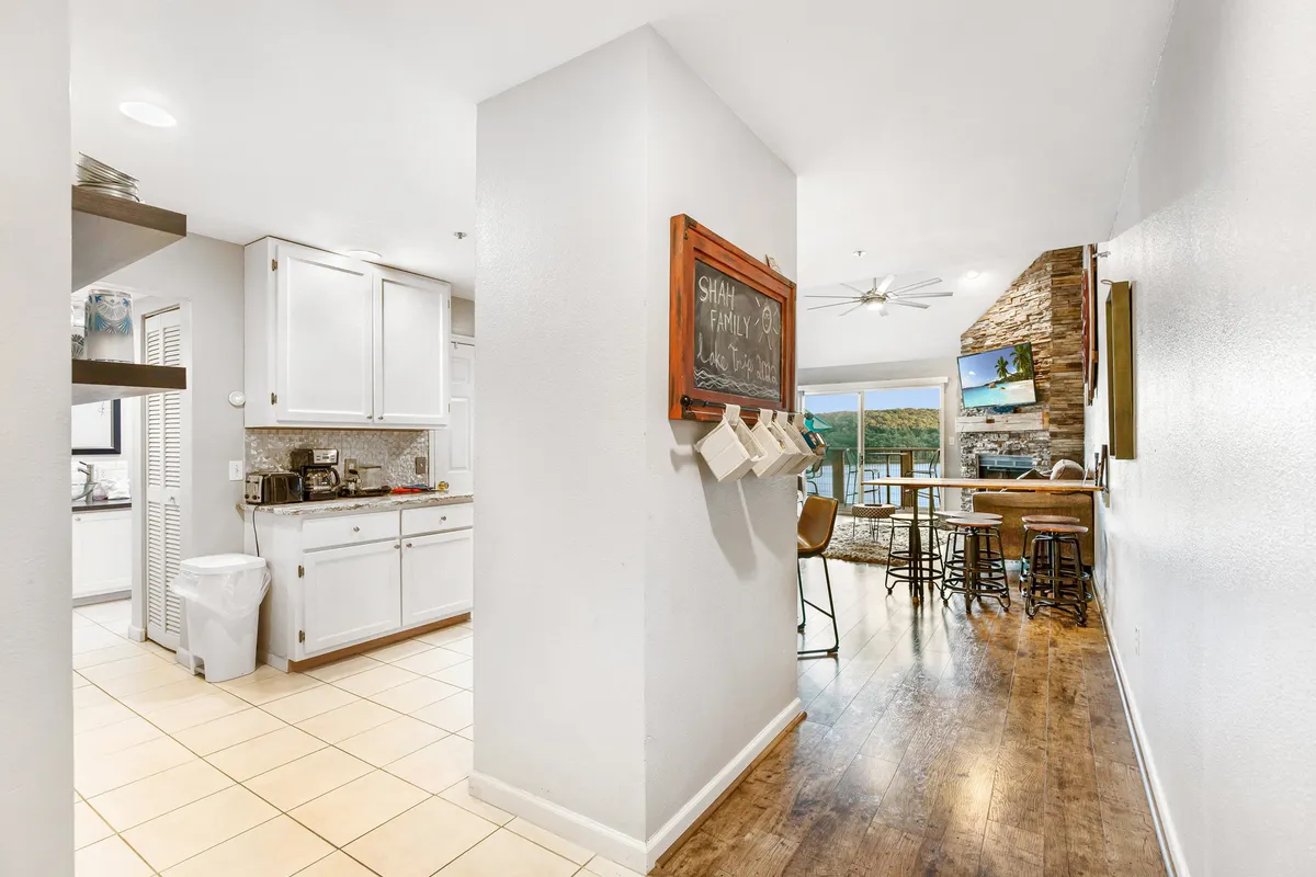 A warm, inviting kitchen with bar seating, wooden cabinets, a chalkboard for notes or recommendations, and views to the outside. The space is set up for family meals, casual brunches, or gathering with friends.