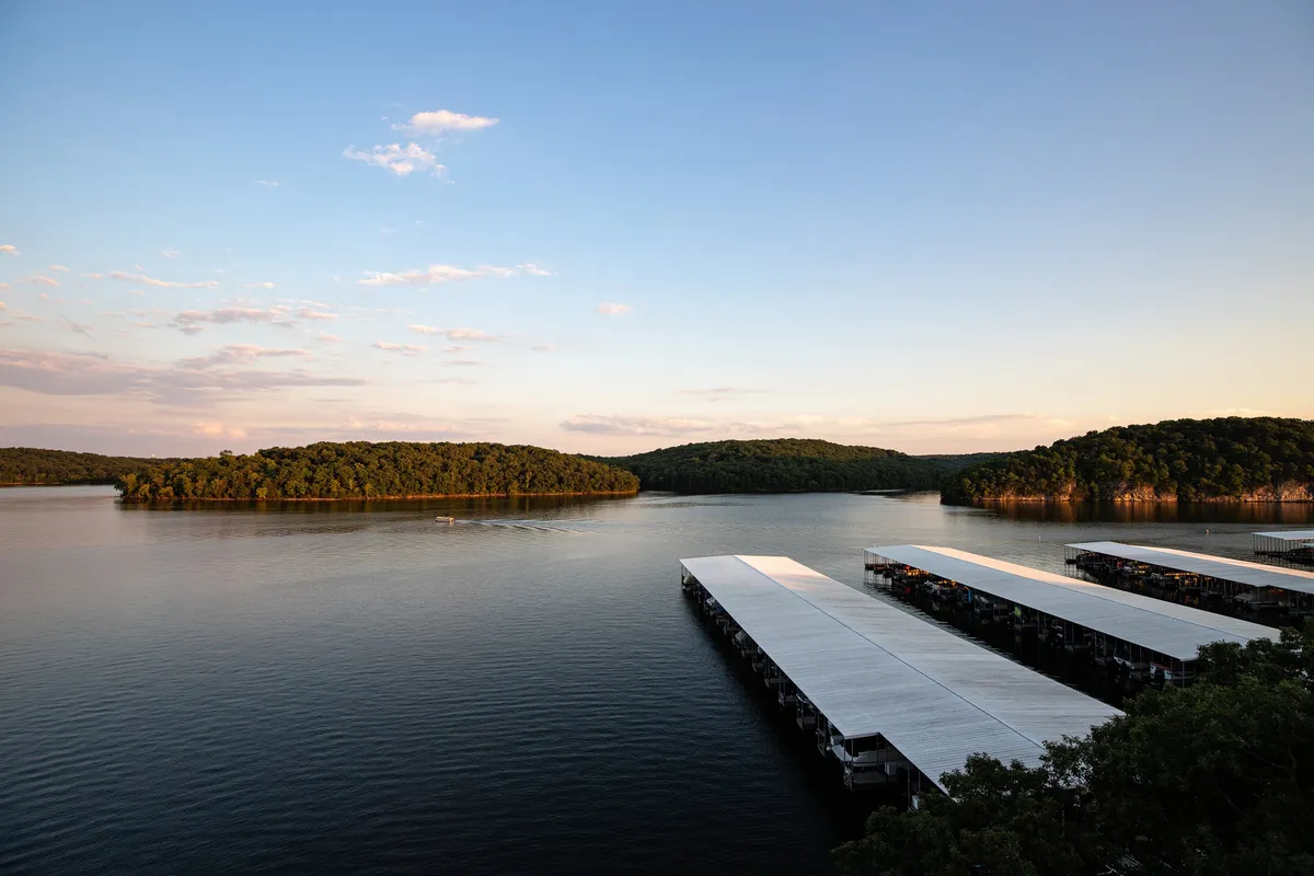 A striking sunset view over waterfront docks with an island on the horizon and a vibrant sky. The scene exudes tranquility, inviting evening cruises or peaceful reflections by the water.